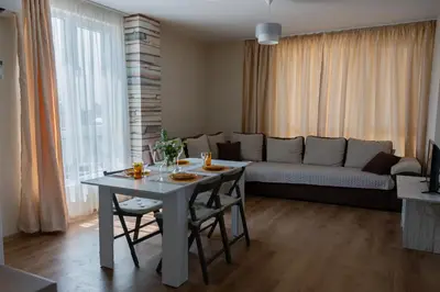 a living room with a table and a couch at Просторен апартамент за семейна почивка in Hisarya