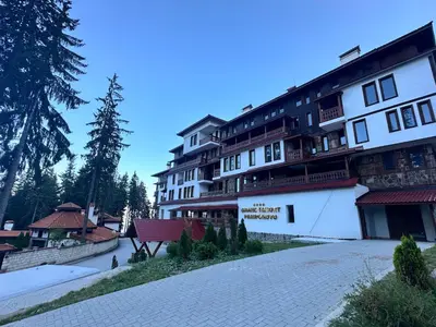 a large building with a bench in front of it at Grand Resort Pamporovo b19 in Pamporovo