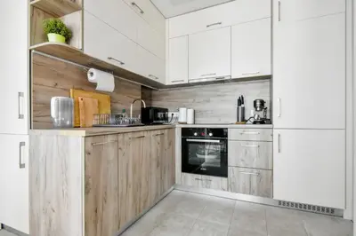 a kitchen with wooden cabinets and white appliances at Charming 2BD with Mountain View by Flat Mаnager in Sofia
