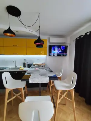 a kitchen with a dining table and white chairs at Nadi in Plovdiv