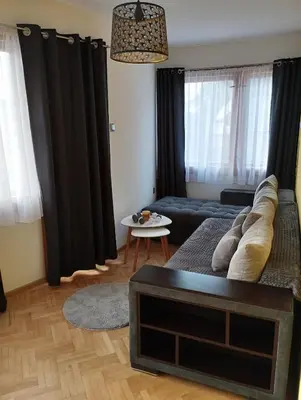 a living room with black curtains and a couch at Nadi in Plovdiv