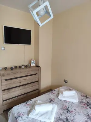 a bedroom with a bed and a tv on the wall at Nadi in Plovdiv