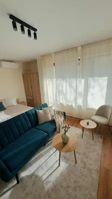 a living room with a blue couch and a bed at Modern Studio near Ski Lift - Cedar Lodge 4,Bansko by Flat Mаnаger in Bansko
