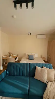 a blue couch in a room with a bed at Modern Studio near Ski Lift - Cedar Lodge 4,Bansko by Flat Mаnаger in Bansko