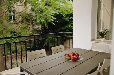 a bowl of fruit on a wooden table on a balcony at Elegant Escape-High Ceilings, Balcony & Piano by Flat Mаnager in Sofia