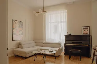 a living room with a couch and a piano at Elegant Escape-High Ceilings, Balcony & Piano by Flat Mаnager in Sofia