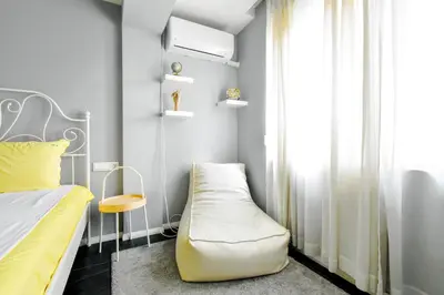 a bedroom with a bed and a chair next to a window at Bright Central Sofia Flat with Coffee-Lovers Touch by Flat Mаnager in Sofia