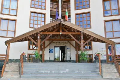 a building with a flag on top of it at Cozy Flat with Pool & Mountain Views, Near Gondola by Flat Mаnаger in Bansko