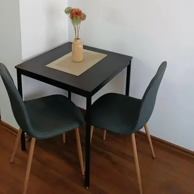 a black table with two chairs and a vase with flowers at Bella apartment Bansko in Bansko
