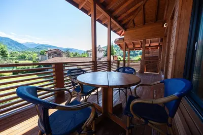 a porch with a table and chairs on a balcony at Къща за гости 