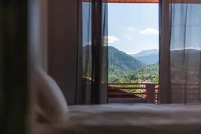 a view of a mountain from a bedroom window at Къща за гости 