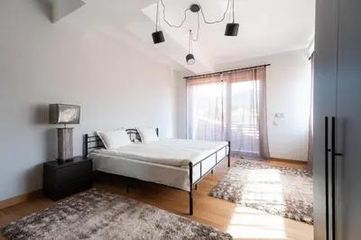 a bedroom with a bed and a large window at Къща за гости 