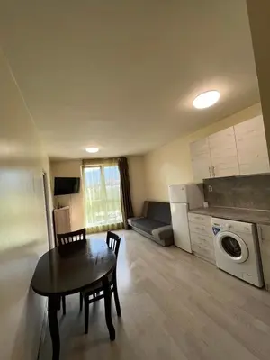 a small living room with a table and a kitchen at Student City Vitosha View Apartment in Sofia