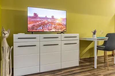 a white dresser with a flat screen tv on top at 20th Residence One Bedroom Apartment - Private Parking Included in Sofia