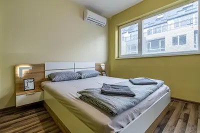 a bedroom with a bed with two towels on it at 20th Residence One Bedroom Apartment - Private Parking Included in Sofia