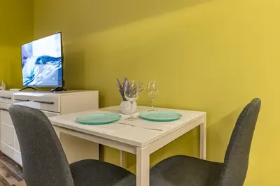 a dining room with a table with chairs and a tv at 20th Residence One Bedroom Apartment - Private Parking Included in Sofia