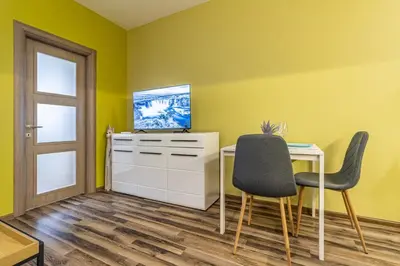 a yellow room with a desk and two chairs at 20th Residence One Bedroom Apartment - Private Parking Included in Sofia