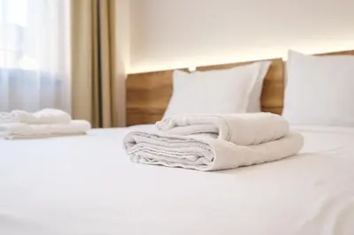 a pile of towels sitting on top of a bed at 2-Bedroom Apartment in the City Center in Plovdiv