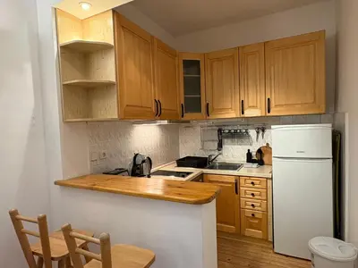 a kitchen with wooden cabinets and a white refrigerator at Charming Loft Sofia Center in Sofia