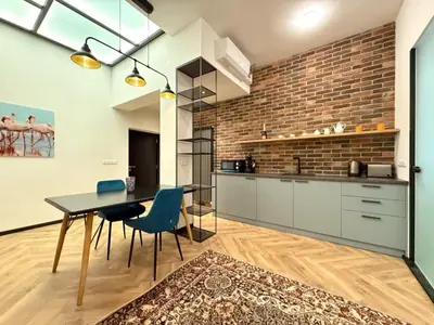 a kitchen with a table and chairs and a brick wall at London - English Basement Studio in Sofia