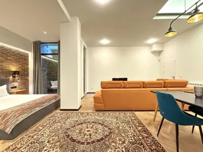 a bedroom with a bed and a couch and a table at London - English Basement Studio in Sofia