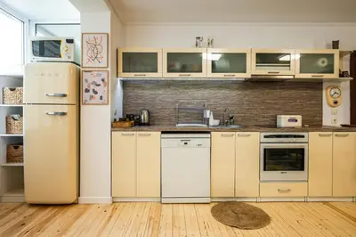 a kitchen with white appliances and wooden floors at Bendida Classic in Velingrad
