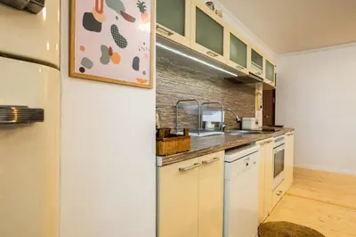 a kitchen with white cabinets and a refrigerator at Bendida Classic in Velingrad