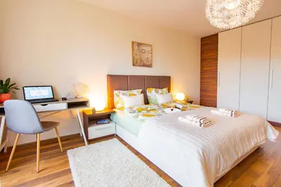 a bedroom with a bed and a desk with a computer at Domus Apartment Amber with Parking in Plovdiv