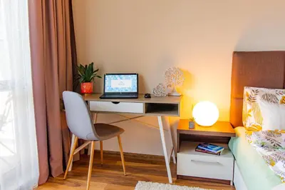 a bedroom with a desk with a laptop computer on it at Domus Apartment Amber with Parking in Plovdiv