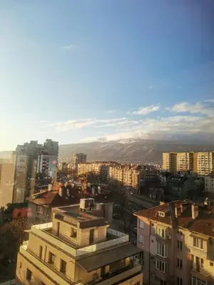 a city with buildings and mountains in the background at Artsy Penthouse & mountain view in Sofia