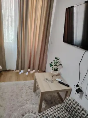 a living room with a table and a tv at Apartament Khan Kubrat in Sandanski