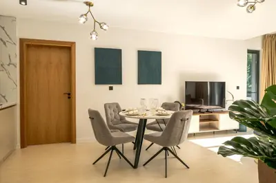 a dining room with a table and chairs and a television at Einik Luxury Apartments in Velingrad