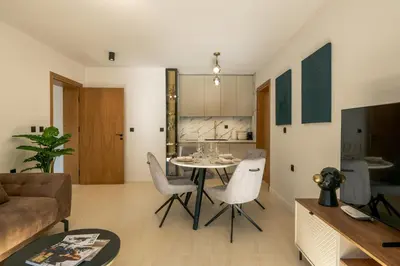 a living room with a table and chairs at Einik Luxury Apartments in Velingrad