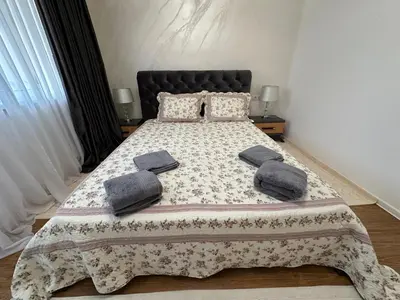 a bedroom with a bed with pillows on it at Apartament Avangard in Pazardzhik