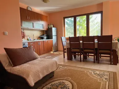 a kitchen and dining room with a couch and a table at The Old Walnut House in Terziysko
