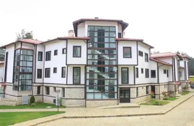 a large white building with a lot of windows at Everwood Hotel & Restaurant in Govedartsi