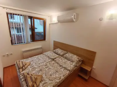 a small bedroom with a bed and a window at Апартамент Мария in Bansko