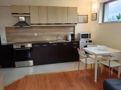 a kitchen with a table and a sink and a stove at Апартамент Мария in Bansko