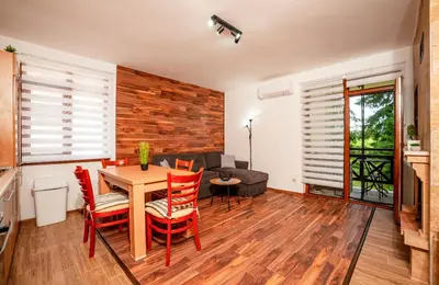 a living room with a table and red chairs at Oxygen Time in Smolyan