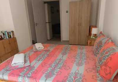 a bedroom with a bed with a red comforter at Wendy House - Central Sofia - 3BRDR - Private Courtyard - 5 min to Vitosha blvd in Sofia