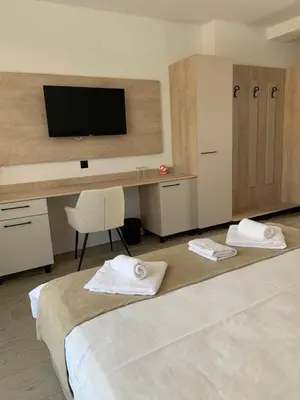a room with a bed and a desk with a television at Zlate Home in Zlatograd