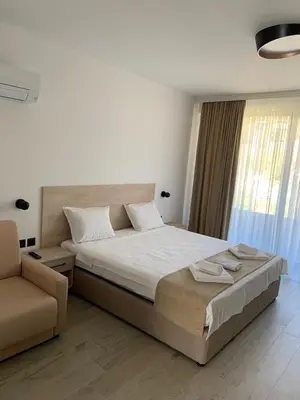 a bedroom with a large bed and a chair at Zlate Home in Zlatograd