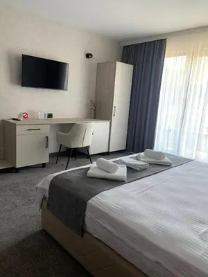 a bedroom with a bed with a desk and a television at Zlate Home in Zlatograd