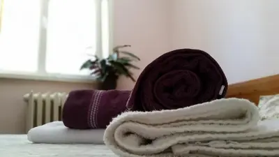 a pile of towels sitting on top of a bed at Boeritza Hotel Complex in Vladaya