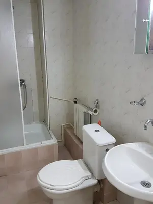a white bathroom with a toilet and a sink at Boeritza Hotel Complex in Vladaya