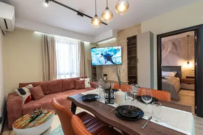a living room with a couch and a table with chairs at Vutovi's corner made with care 2 in Bansko