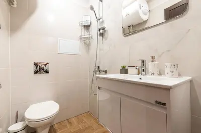 a white bathroom with a toilet and a sink at Vutovi's corner made with care 2 in Bansko