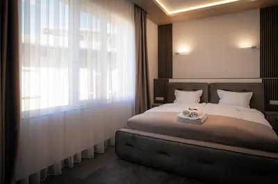 a bedroom with a bed and a large window at Royal View Guest House in Dospat