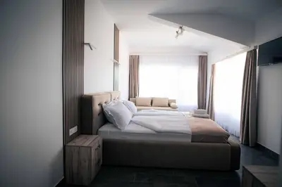 a bedroom with a bed and a large window at Royal View Guest House in Dospat