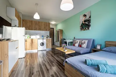 a living room with a bed and a kitchen at Student City Studio With Mountain View Balcony and Underground Parking 1 in Sofia